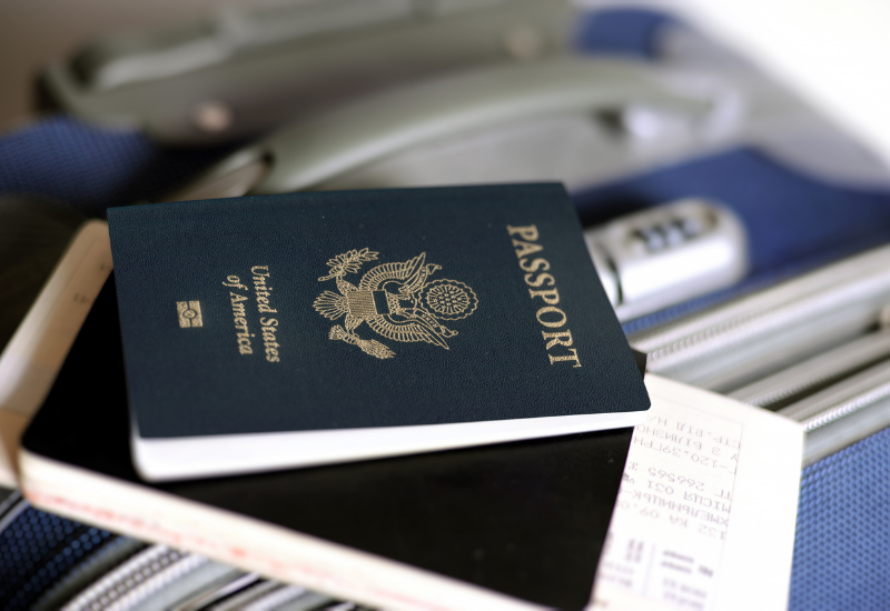 US passport with airline ticket and suitcase